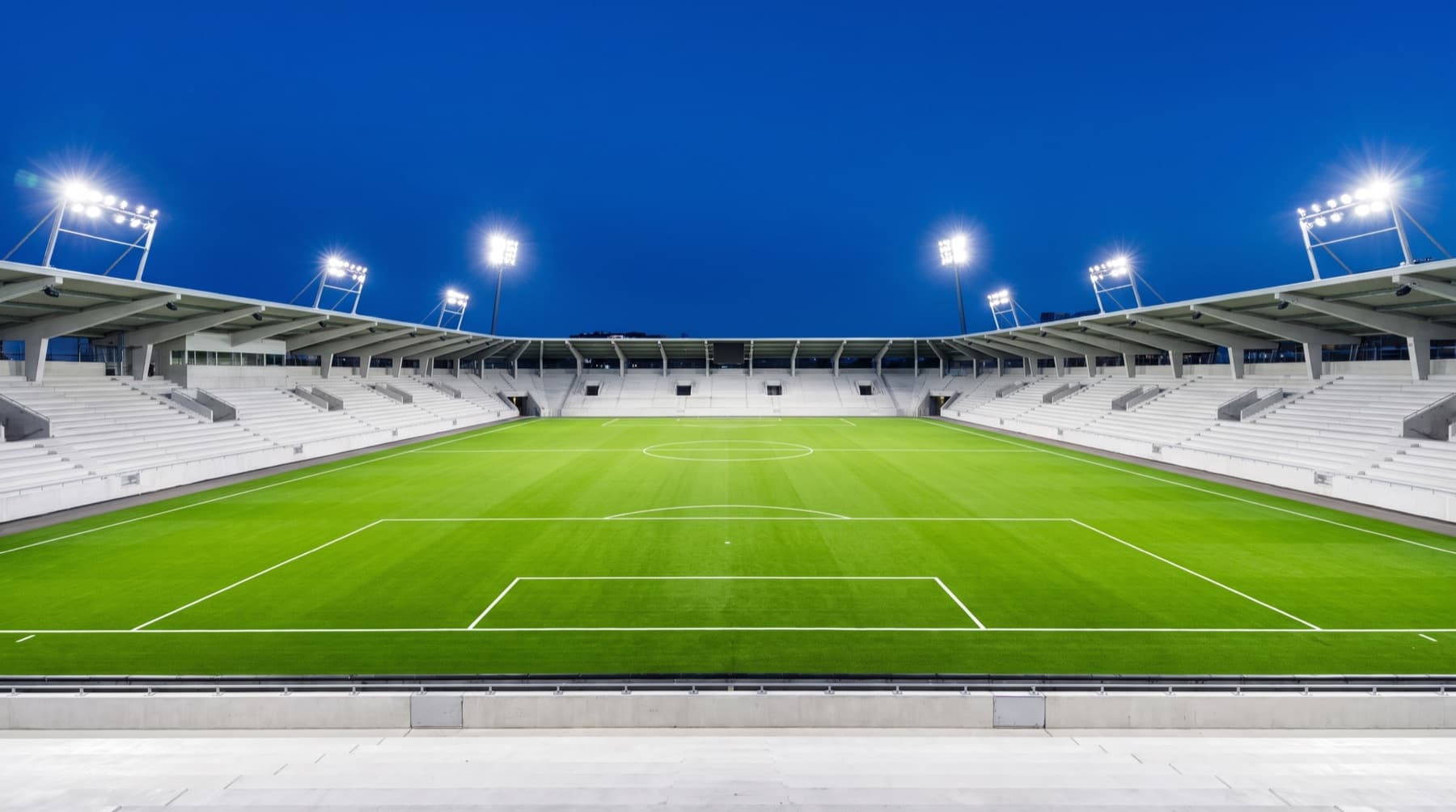 Flomlyst fotballstadion i blåtimen før kveldskamp