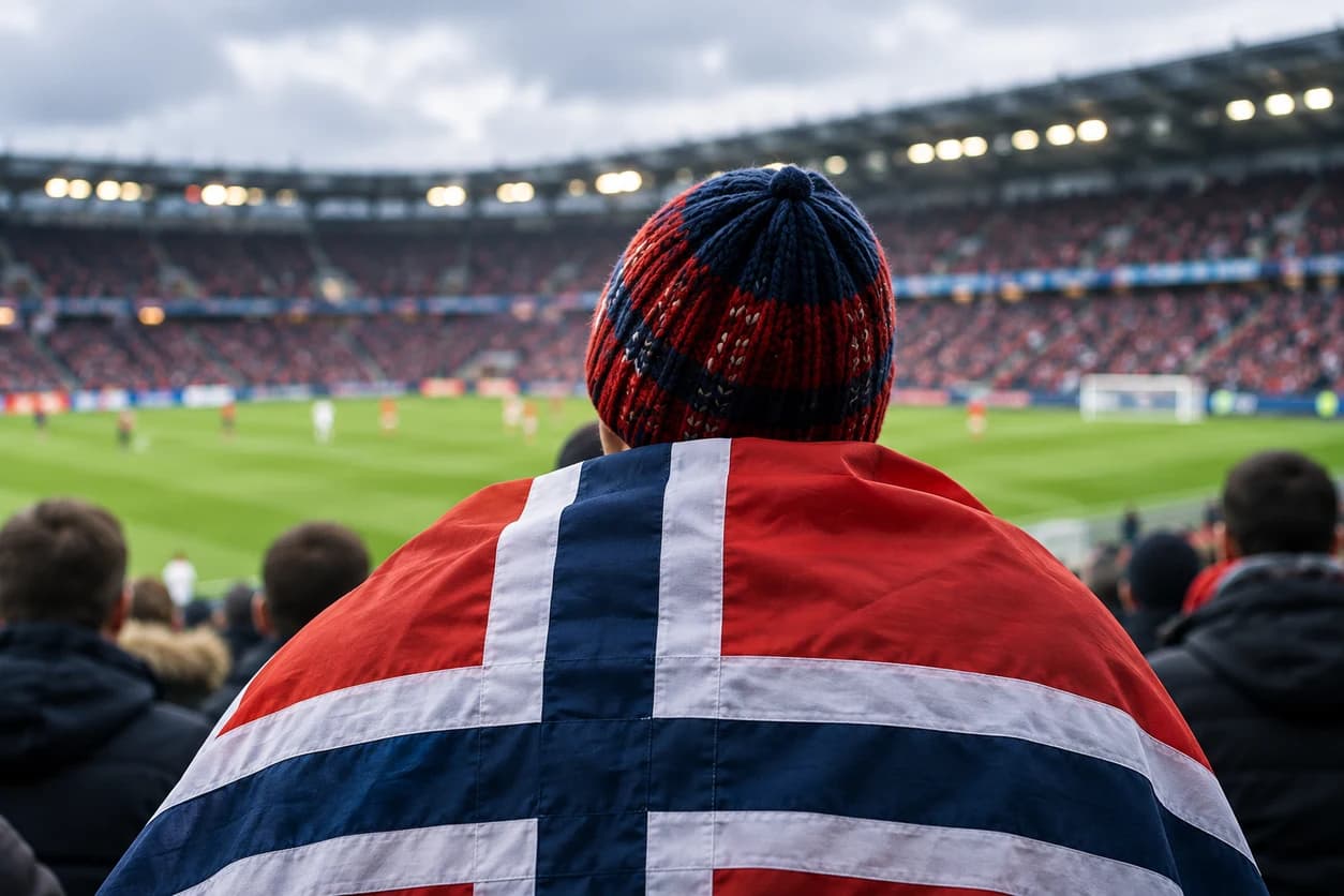 Illustrasjon av en norsk supporter med flagget over skuldrene, vendt mot fotballbanen.